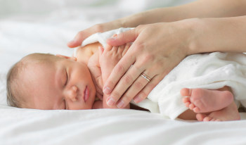 parent touching premature infant