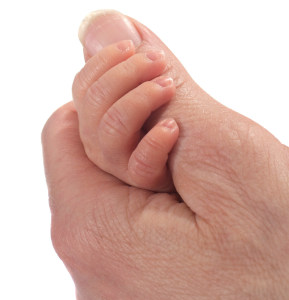 Tiny baby hand in parent's hand.
